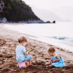 enfants jouant avec du sable sur la plage