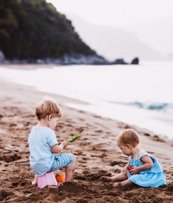 enfants jouant avec du sable sur la plage